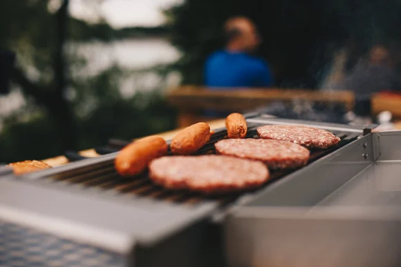 Bratwürste und Burger auf einem Elektrogrill